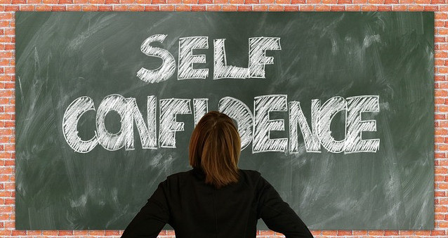 A woman in front of the chalkboard with self-confidence displayed
