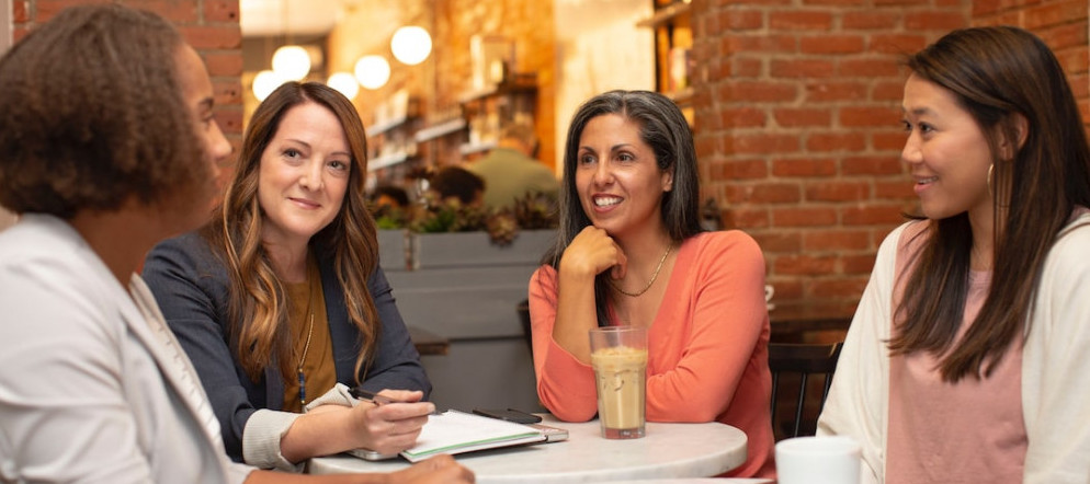 Picture of women having a discussion at a table in a cafe