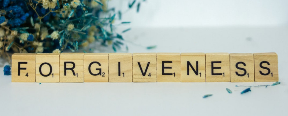 Scrabble blocks spelling out the word forgiveness.